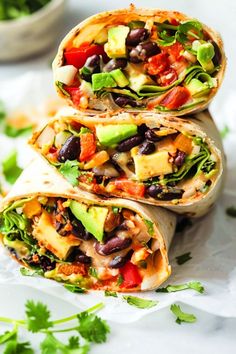 three burritos stacked on top of each other with vegetables and black beans in them