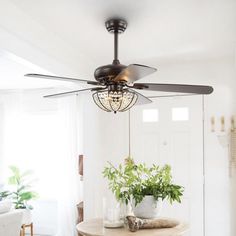 a ceiling fan is hanging from the ceiling in a room with white walls and wooden floors