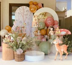 a birthday party with balloons, decorations and deer figurines