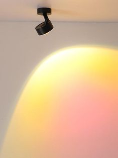 a light that is on in the ceiling next to a wall with an object hanging from it's side