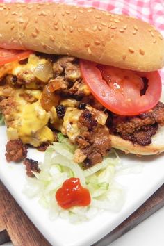 a sandwich on a plate with lettuce, tomato and other toppings next to a knife