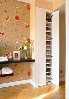 a room with a book shelf and flowers on the wall