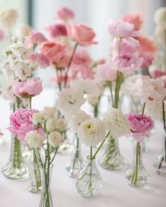 there are many vases with flowers in them on the tableclothed table cloth