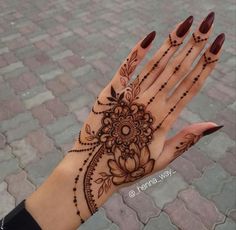 a woman's hand with henna tattoos on it and the words wow written in arabic