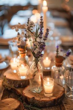 a table topped with candles and vases filled with flowers next to each other on top of wooden slices