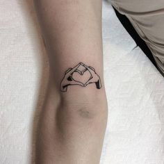 a person with a heart tattoo on their arm