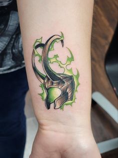 a tattoo on the arm of a woman with green leaves and an animal's head