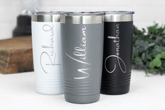 three personalized stainless steel tumblers sitting next to each other on a white surface