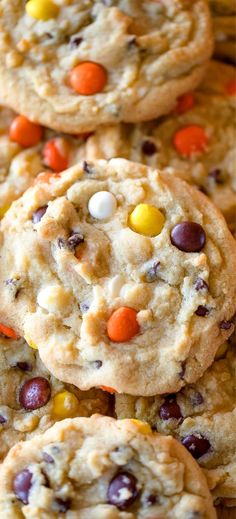 cookies with candy corn and m & ms on top are stacked up in rows, ready to be eaten