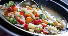 a close up of a bowl of food with broccoli and carrots in it