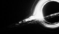 a black and white photo of a circular object in the dark with light streaks around it