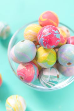 colorful marbles in a glass bowl on a blue background