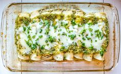 a casserole dish with broccoli, cheese and sauce in it on a wooden table