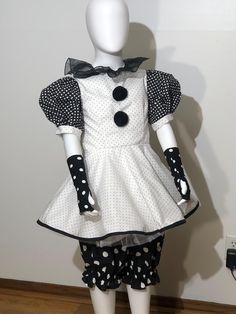 a white mannequin with black polka dots on it's dress and gloves