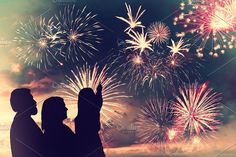 two people are looking at fireworks in the sky