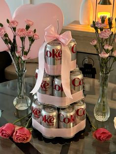 a cake made out of cans and flowers on a table with roses in vases