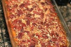 a casserole dish with pecans and other toppings on it sitting on a counter