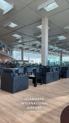 an airport lobby with blue chairs and tables