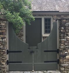 a stone building with a large gate in front of it and two windows on each side