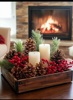 a wooden box filled with pine cones and candles on top of a table next to a fire place