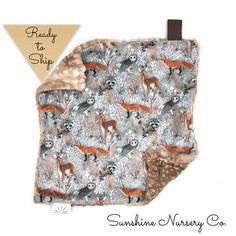 a blanket with animals on it and a brown tag hanging from the back of it