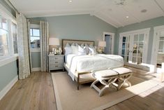 a bedroom with blue walls and white furniture