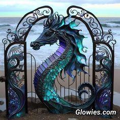 a metal gate with a sea horse on it's side next to the ocean