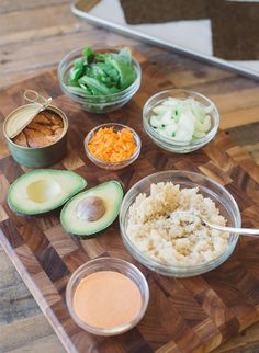 an avocado, rice, carrots and other ingredients on a cutting board