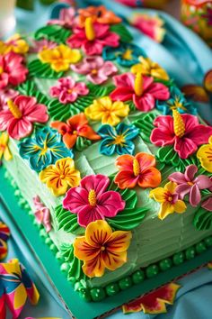 a cake decorated with flowers on top of a blue table cloth next to other decorations