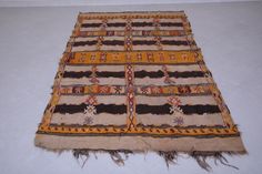 an old rug is laying on the floor with fringes and beads hanging from it