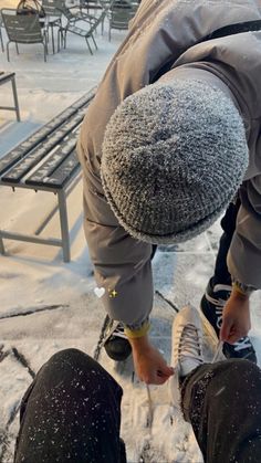 two people standing in the snow with their feet on each other's legs,