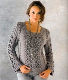 a woman in grey sweater and jeans posing with her hands on her hips, looking at the camera