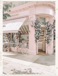 a pink building with flowers on the outside and bicycles parked outside in front of it