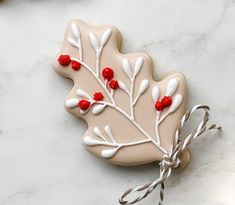 a cookie decorated with white icing and red berries on top of a marble table