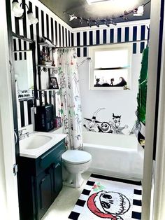 a bathroom with black and white decor on the walls, toilet, sink and bathtub