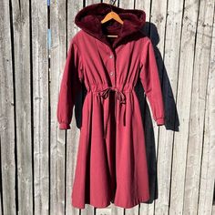 Vintage Belted Princess Coat Hooded Fur Lined Burgundy Wine Long Overcoat Vintage 70s-80s Does 50s Style Princess Coat. Burgundy/Berry Color With Plush Faux Fur Lining, Button Front, And Drawstring Waist Tie Belt. Very Flattering Silhouette. Large Fur Lined Hood. Puffy Sleeve Cuffs. No Pockets. Brand Is Bonders. Made In Usa. Fits Small, Possibly Medium. See Measurements Below For Best Fit. The Material Is Labeled As “All Season Calendar Cloth”, Feels Like A Cotton/Poly Blend. Fur Is Faux. The Fi Hooded Burgundy Outerwear For Winter, Hooded Burgundy Outerwear For Fall, Retro Long Sleeve Hooded Jacket For Fall, Burgundy Hooded Outerwear For Winter, Retro Hooded Jacket With Pockets For Fall, Vintage Hooded Jacket For Cold Fall Weather, Vintage Long Sleeve Parka For Fall, Fall Vintage Long Sleeve Parka, Retro Fall Parka With Pockets