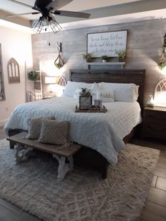 a bedroom with a large bed and wooden headboard on top of a white rug