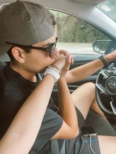 a man sitting in the driver's seat of a car with his hand on his face