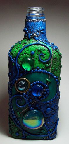 a blue and green glass bottle sitting on top of a table