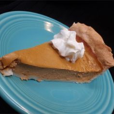 a piece of pie with whipped cream on top sits on a blue plate, ready to be eaten