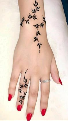 a woman's hand with black leaves on it