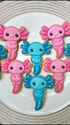 decorated cookies with blue and pink icing on a plate