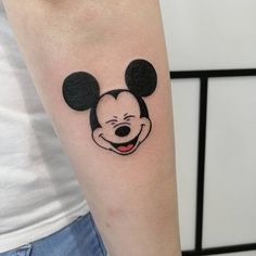 a person with a mickey mouse tattoo on their arm