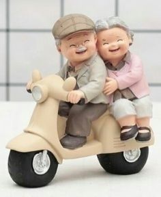 a figurine of two people on a scooter with the man holding the woman's head