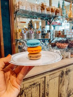 a person holding a plate with two different types of doughnuts on it in front of a store