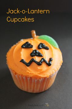 an orange cupcake decorated like a jack - o - lantern