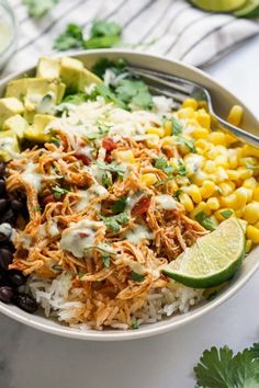 a white bowl filled with rice, black beans and avocado garnish