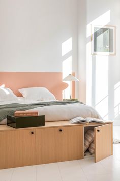 a bed sitting in the middle of a bedroom next to a lamp and book shelf