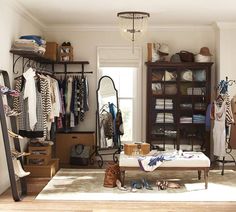 an organized closet with clothes, shoes and other items on display in the center area