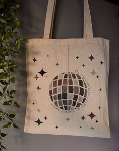 a tote bag hanging on a wall with stars and a disco ball in the middle